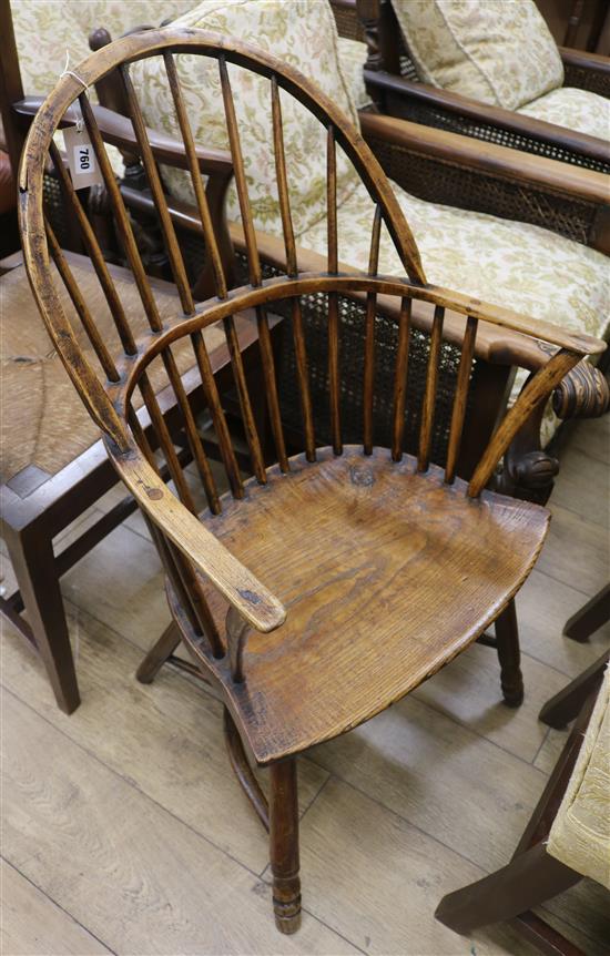 An early 19th century elm and ash stick back elbow chair